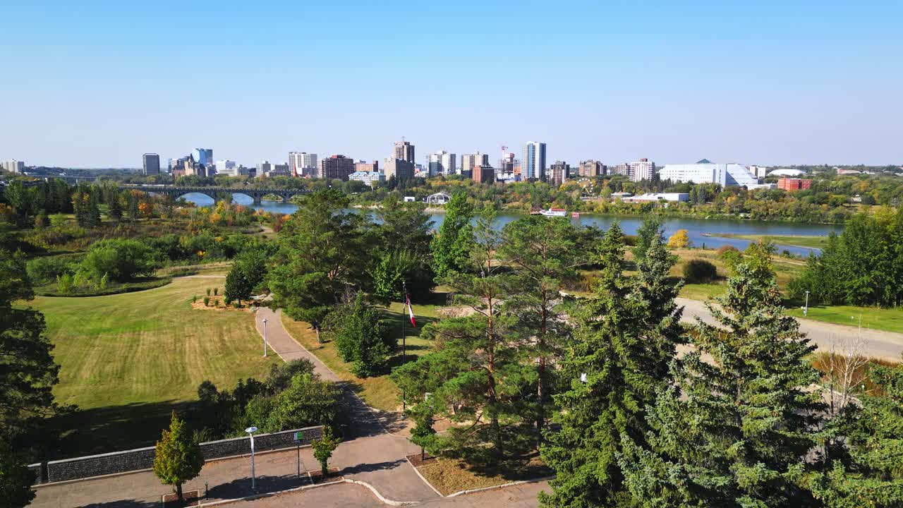 Rising drone shot reveals Saskatoon downtown skyline framed by fall foliage