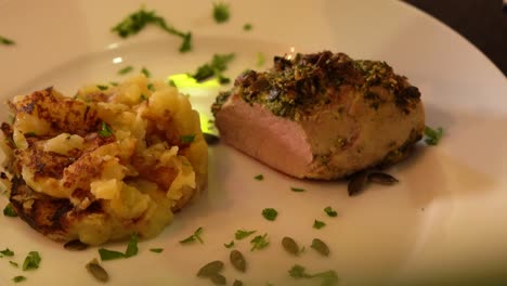 garnish of seeds, cilantro sprinkled over plate of meat and potatoes before serving.