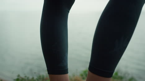 Athletic-woman-legs-standing-beach-hill-closeup.-Strong-girl-feet-on-dry-grass.