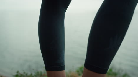 athletic woman legs standing beach hill closeup. strong girl feet on dry grass.