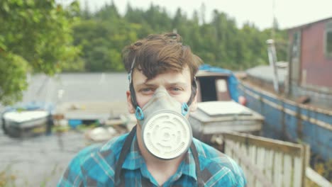 a young man putting on a respirator and visor