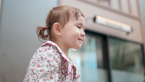 Perfil-De-Una-Joven-Niña-Pequeña-Feliz-Con-Coletas-Mirando-Hacia-Arriba-Y-Sonriendo---Enfoque-Superficial