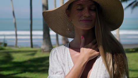 mujer con sombrero de paja en una playa tropical