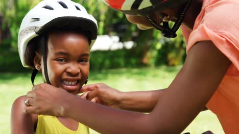 Mujer-Poniéndole-Un-Casco-De-Ciclismo-A-Su-Hija.