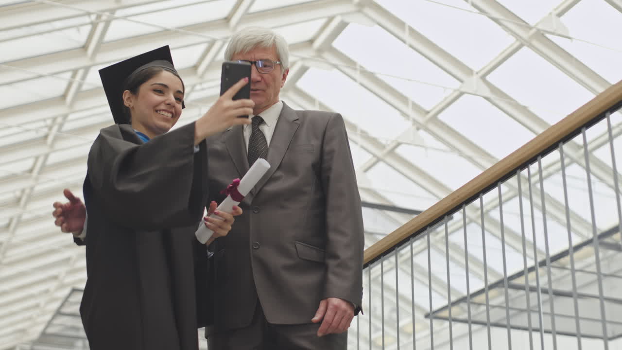 Female Graduate Making Selfie with Aged University Tutor