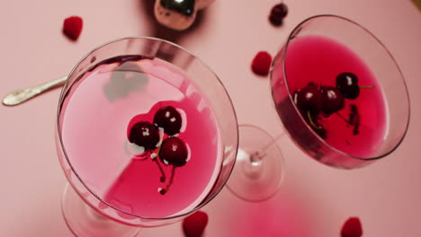 cerrar las bebidas con cerezas y batidor sobre fondo blanco
