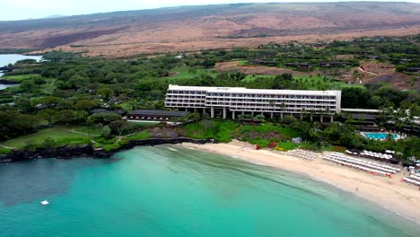 aerial drone view rising over oceanside manua kea beach hotel tourist destination on big island of hawaii