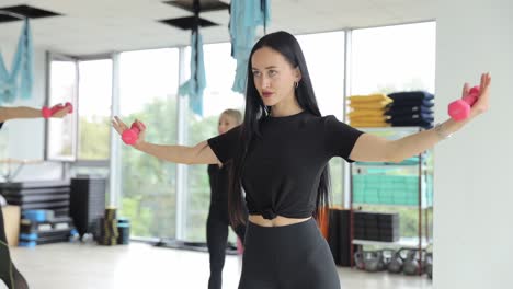 women exercising with dumbbells in a gym
