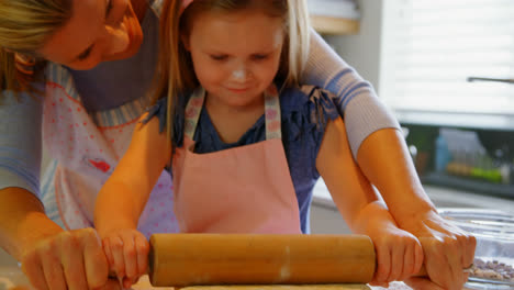 Vorderansicht-Einer-Jungen-Kaukasischen-Mutter-Und-Tochter,-Die-Teig-In-Der-Küche-Eines-Komfortablen-Zuhauses-Rollt,-4K