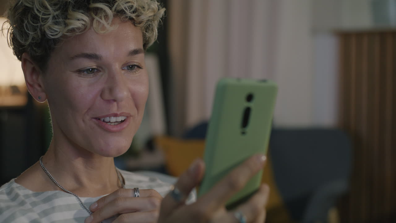 Woman looking at her phone with a joyful expression