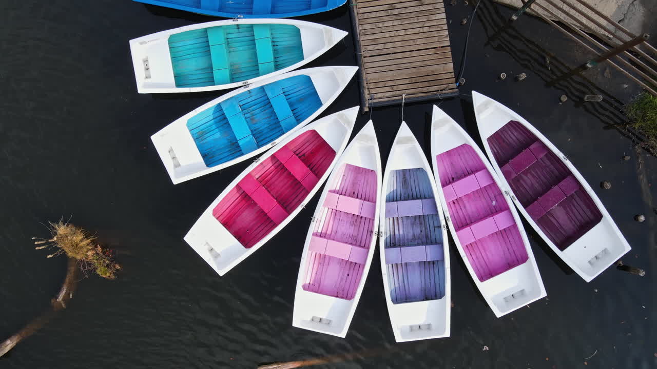 View of The Red Lake with few colored moored boats at a pier, Romania