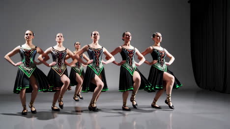 a group of women performing a synchronized dance in elegant costumes