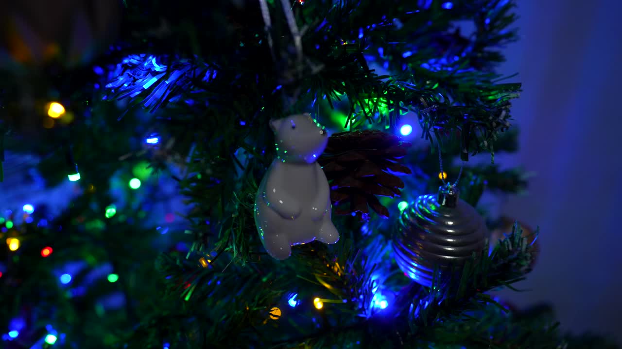 Close-up of ornament on Christmas Tree with colorful lights. Polar bear, balls and lights