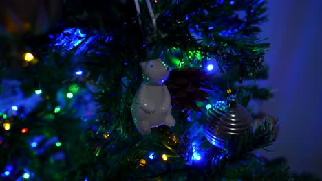 close-up of ornament on christmas tree with colorful lights. polar bear, balls and lights