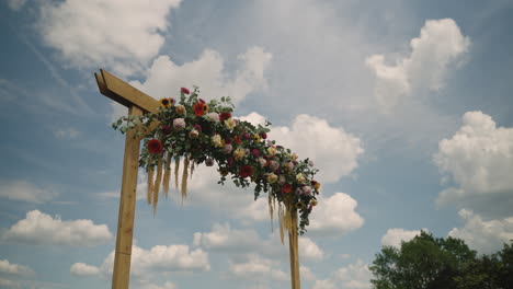 timelapse of an arch of flowers with a blue sky and fast-moving clouds