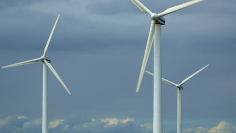 wind turbines rotating against cloudy summer sky, slow pan