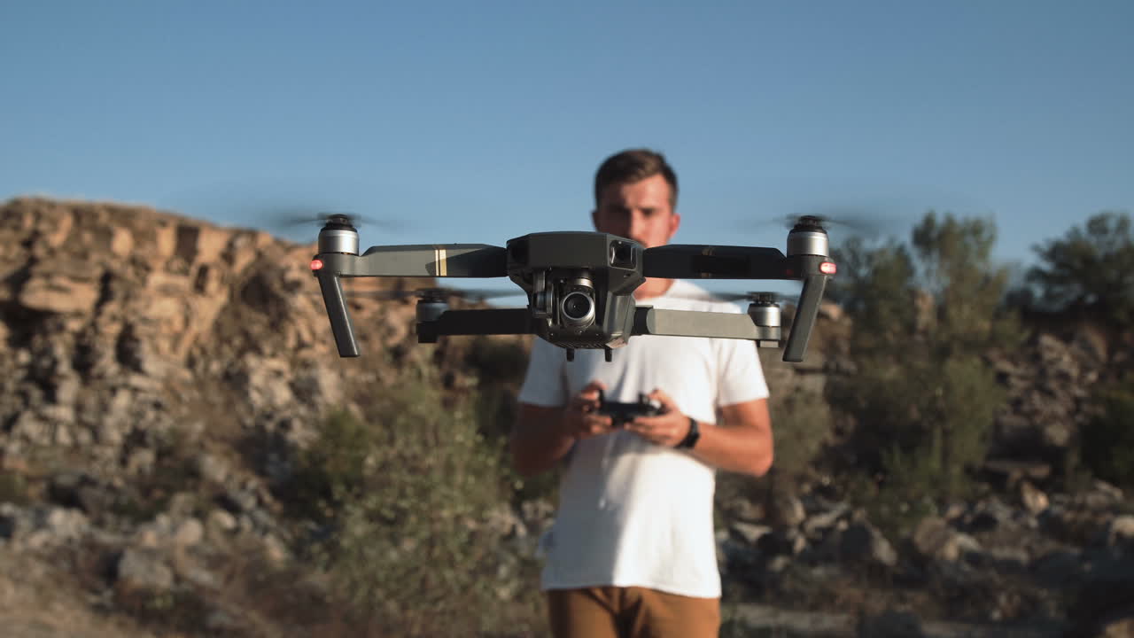 Man flying a drone in a mountainous area