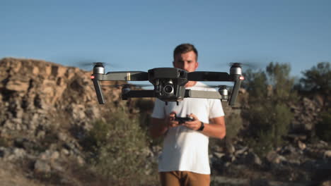 man flying a drone in a mountainous area