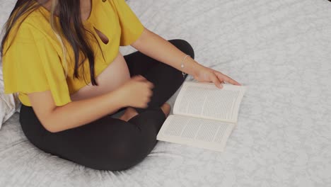 una joven embarazada leyendo un libro
