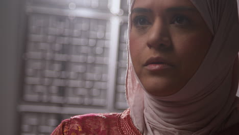 Studio-Head-And-Shoulders-Portrait-Of-Muslim-Woman-Wearing-Hijab-Praying-In-Mosque-Or-At-Home