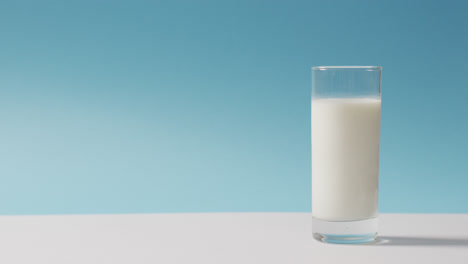 video of glass of fresh milk over blue background