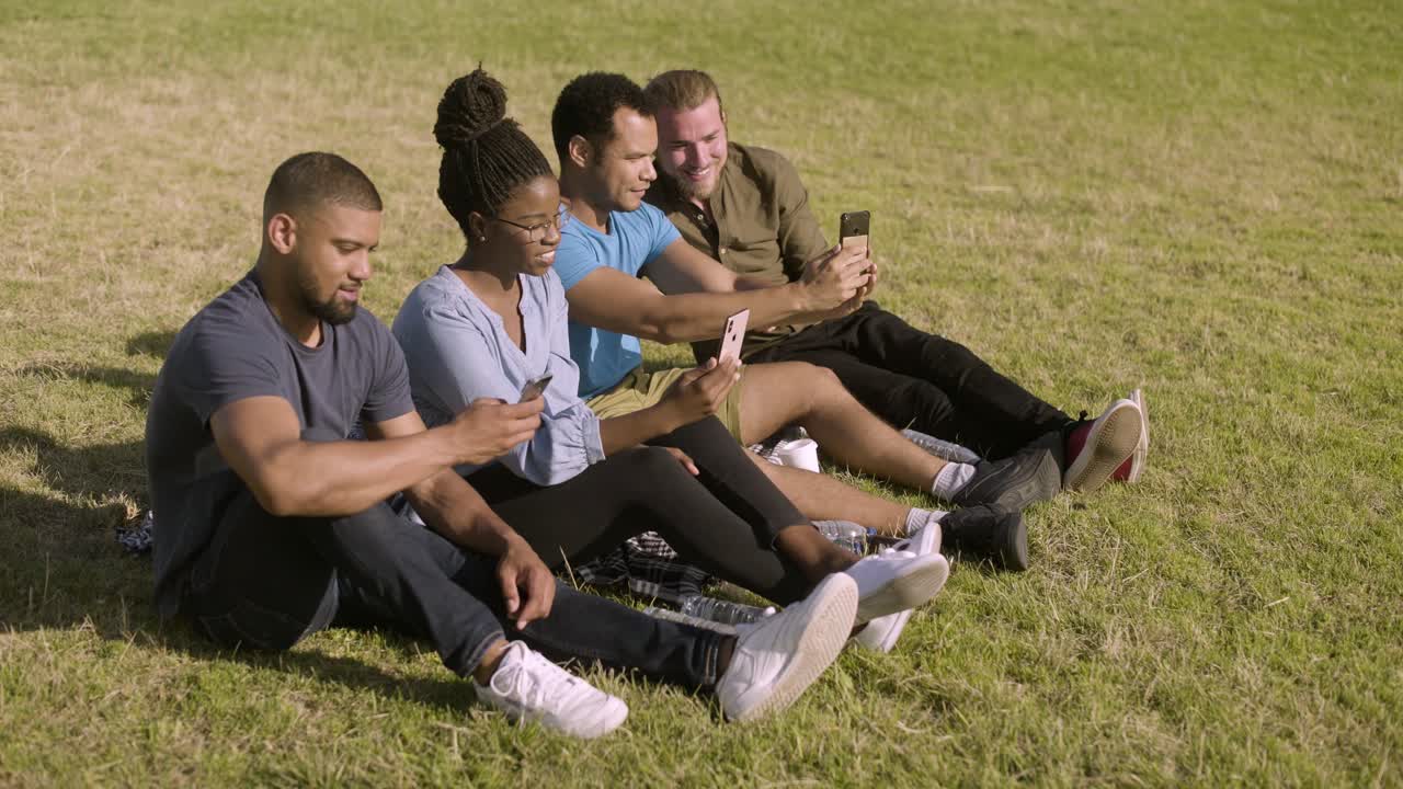 jóvenes sonrientes tomando selfies con sus teléfonos inteligentes