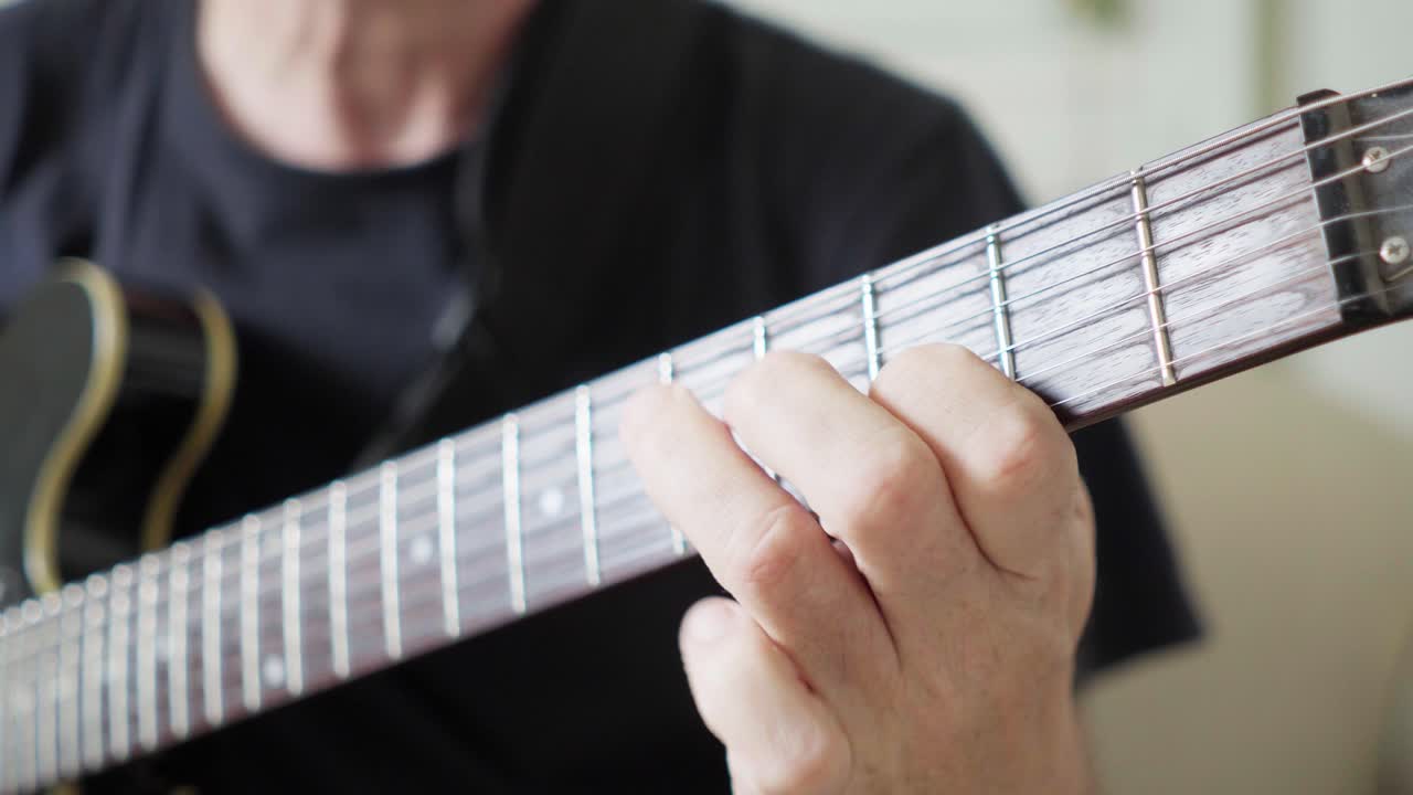 Close-up of a guitarist's left hand improvising on a 335 electric guitar