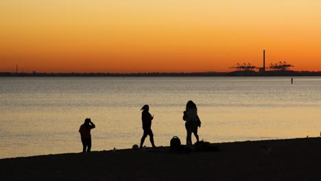 people enjoying sunset at st kilda beach