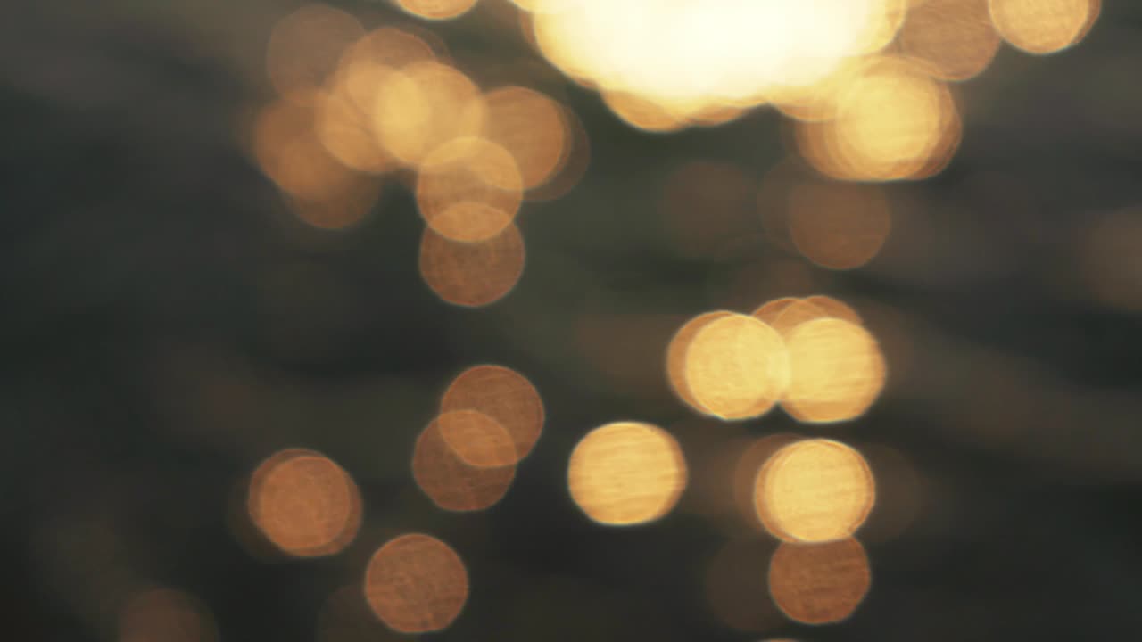 el sol de la mañana se refleja en la superficie del mar, fuera de enfoque imágenes que crean bonitas bolas de bokeh amarillas, fondo natural abstracto