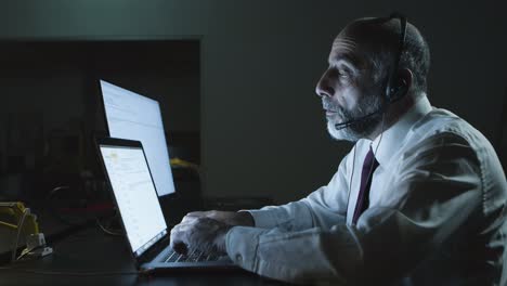 hombre serio con auriculares usando una computadora portátil