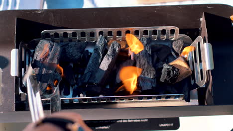 placing charcoal in a small grill to start the fire