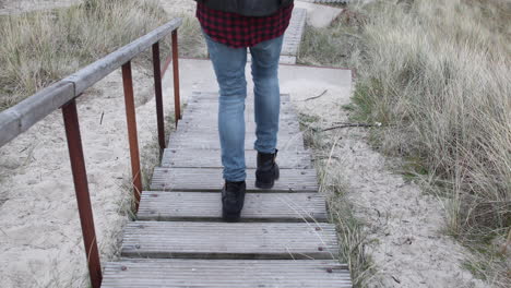 hombre hipster caminando por las escaleras en las dunas