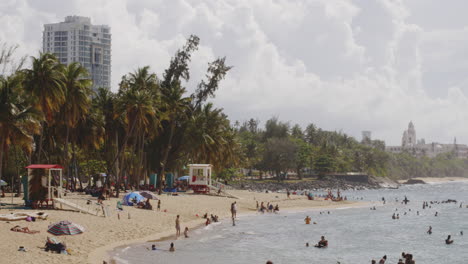 persons relaxing lying around on the shore at balneario del escambron, san juan, puerto rico