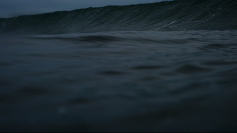 in water view of ocean surface rising to create face and barrel of wave breaking