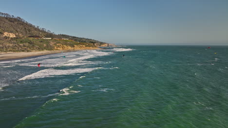 Davenport-California-Aerial-v1-drone-fly-around-waddell-beach-capturing-post-bushfire-landscape-with-kite-boarders-surfing-the-wind,-flying-high-in-the-sky---Shot-with-Mavic-3-Cine---May-2022