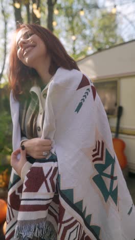 woman enjoying autumn day in a camping trailer