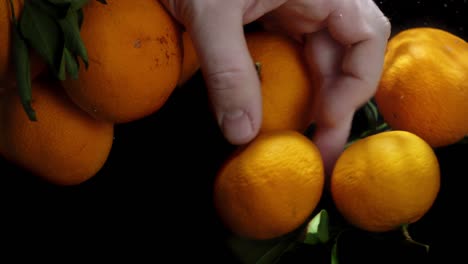 man's hand under the water with fresh tangerines.