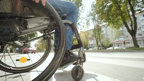 man with disabilities in wheelchair crossing street road