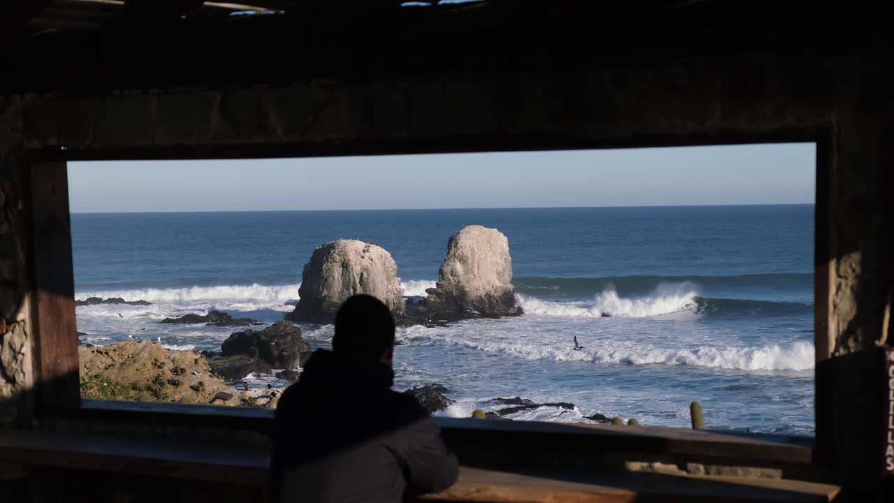 남자는 칠레 피칠레무의 뉴노멀에서 안면 마스크 없이 푼타 데 로보스 서핑 포인트 칠레를 향해 프레임이나 창을 통해 본다