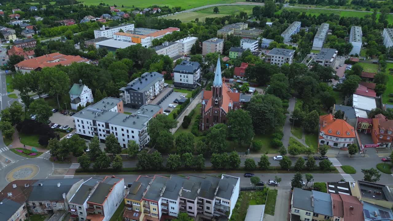 The comprehensive cityscape of Łowicz, Poland, from the historic town center and Cathedral to the surrounding residential areas and modern infrastructure, including the railway overpass