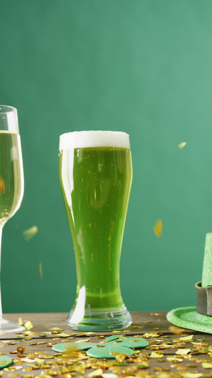 Vertical video of of st patrick's green hat, beer and champagne glasses on green background