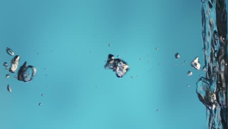shiny Air Bubbles Rising up on Calm Surface of Water and Bursting Shiny Air Bubbles Rising up on Calm Surface of Water Bursting and Forming Splash Freshness of Clear Blue Liquid Poured into Container Transparent Blue Aqua with Light Glare Close up Liquid through the Glass