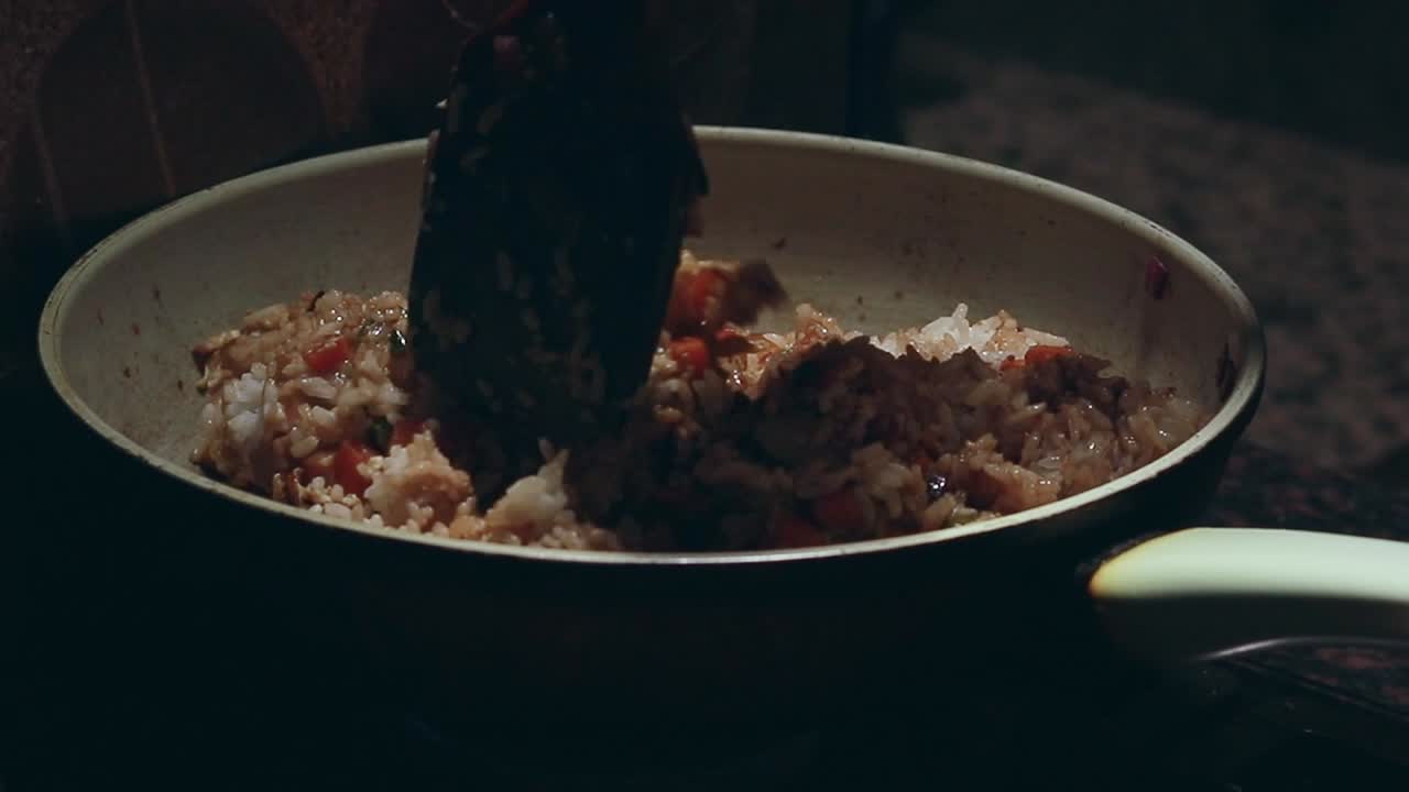 Rice and vegetables stirred in a pan, creating a warm and cozy home-cooked fried rice meal