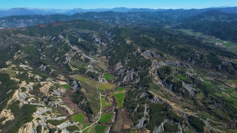 Paisaje-Rural-Con-Colinas-Que-Se-Extienden-Hasta-El-Horizonte-Y-Un-Encantador-Pueblo-De-Montaña-En-Medio-De-Verdes-Tierras-Agrícolas-En-Albania