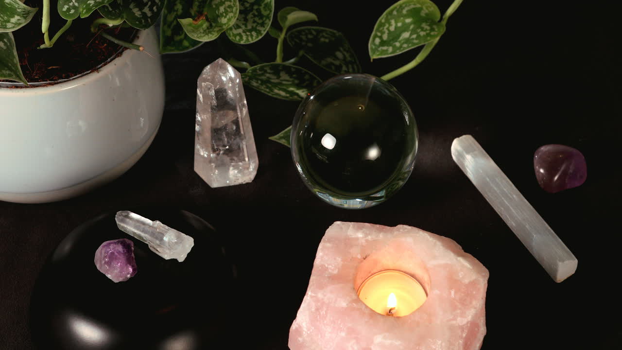Various crystals and a crystal ball during a candle magick ritual