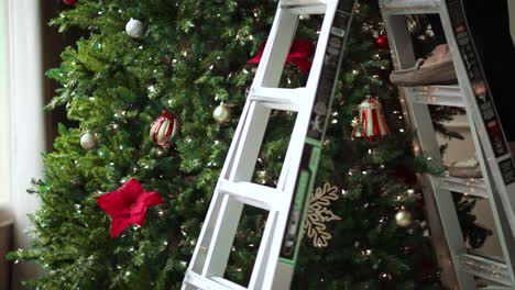 pies en la escalera de tijera frente a un árbol de navidad en la casa - tiro medio, control deslizante a la derecha