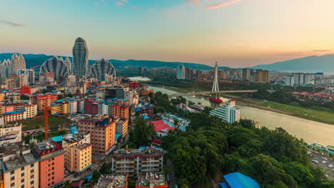 Spectacular-Real-shot-Buddhist-Temple,-City-skyline-Buildings-in-Chinese-Touristic-Travel-Destination-of-Xishuangbanna,-sunset-timelapse