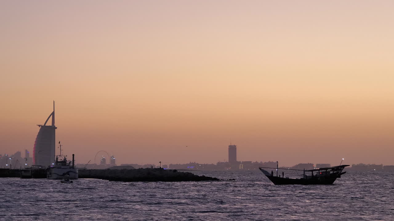 백그라운드에서 버즈 알 아랍과 일몰 후 바다에서 silhouetted 도우