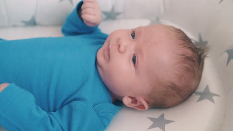 adorable baby in bodysuit bothers legs in sleeping cocoon