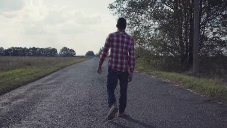 man walking down a country road